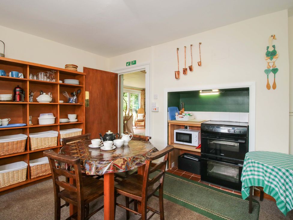 A kitchen with a table and chairs at Kwerky Cottage