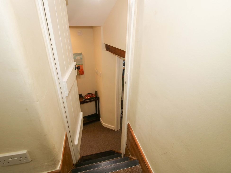 A staircase with a door and a table at Kwerky Cottage
