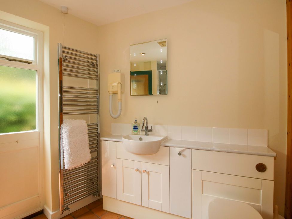 A bathroom with a sink and mirror at Kwerky Cottage in 