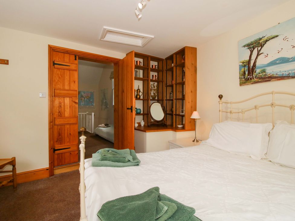 A bedroom with a bed and dresser at Kwerky Cottage