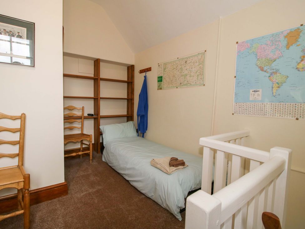 A bedroom with a bed and a chair at Kwerky Cottage 