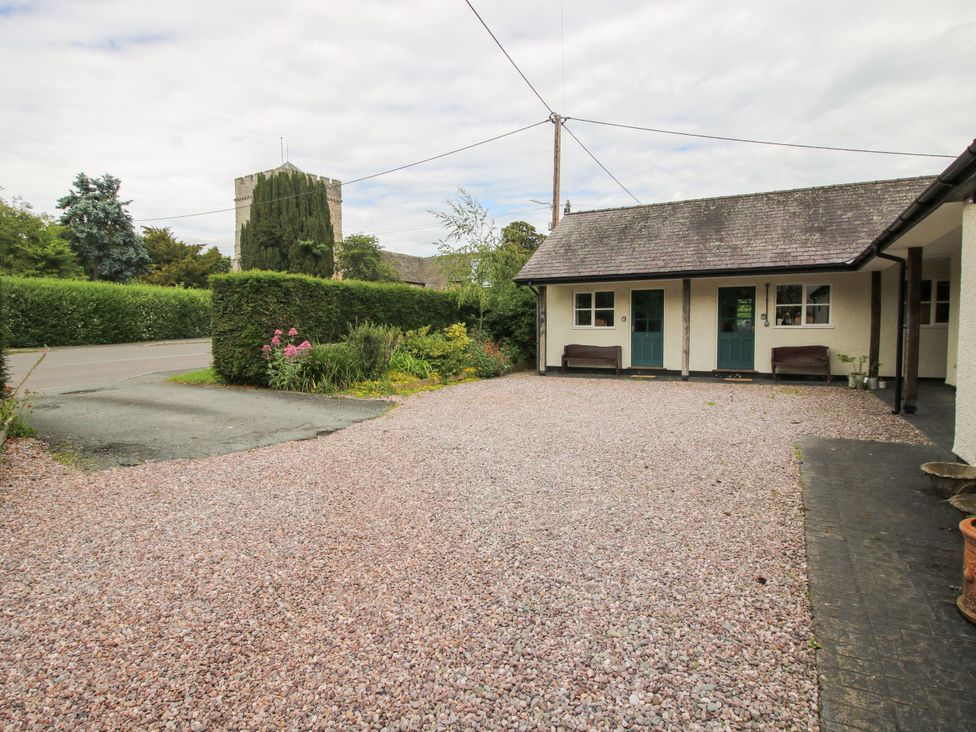 An outdoor area with a gravel driveway and flower beds at Kwerky Cottage Lydbury North
