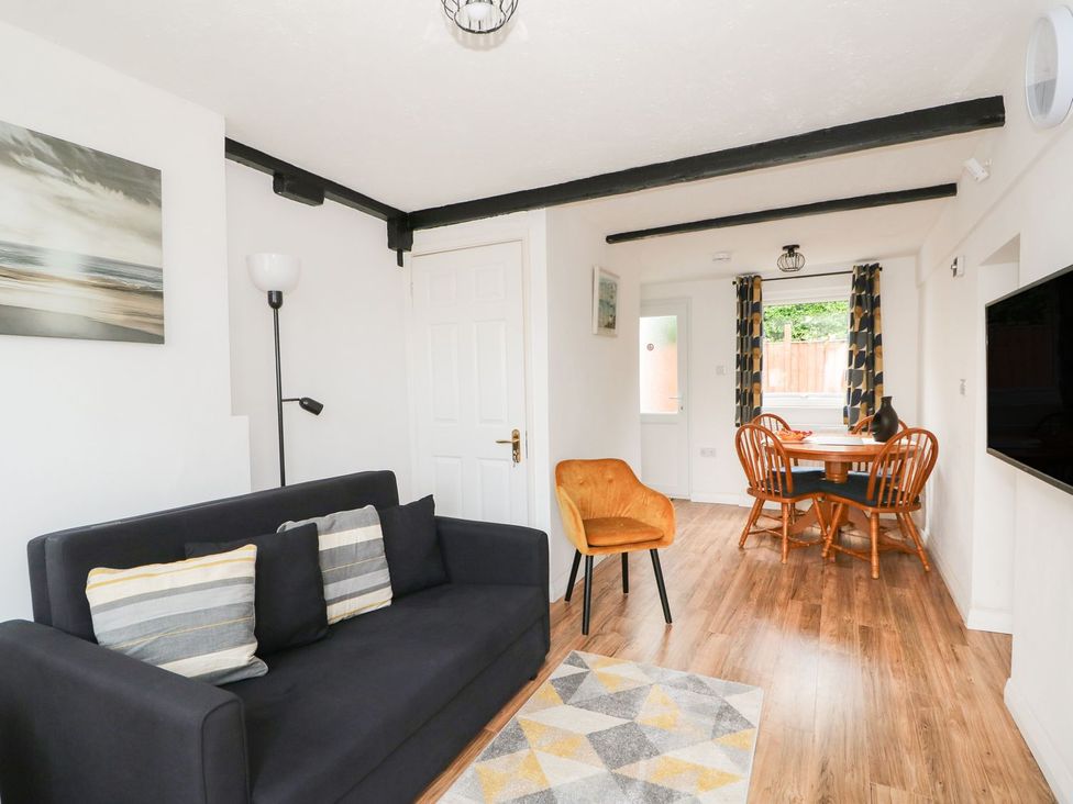 A living room with a sofa and dining table at Oar Cottage in Mablethorpe