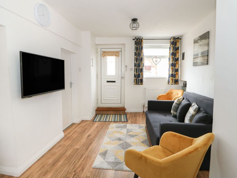 A living room with a sofa and television at Oar Cottage in Mablethorpe