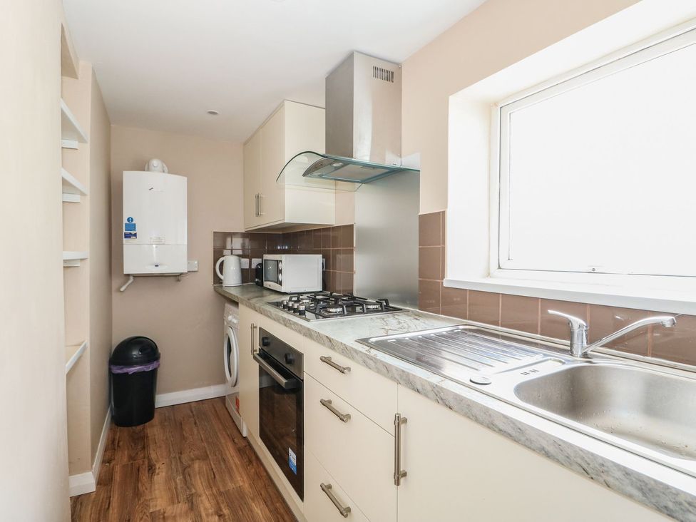 A kitchen with appliances including a gas stove and washing machine at Oar Cottage in Mablethorpe