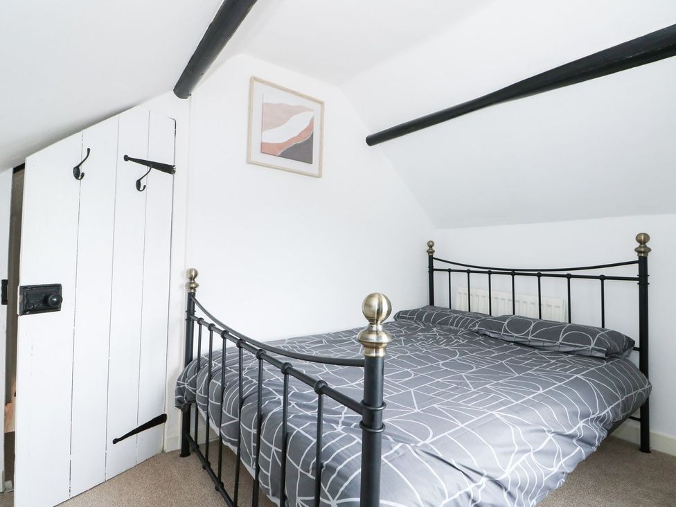 A bedroom with a bed and a door at Oar Cottage in Mablethorpe