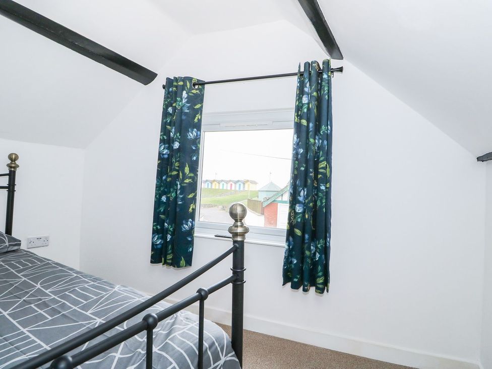 A bedroom with a bed and window at Oar Cottage in Mablethorpe