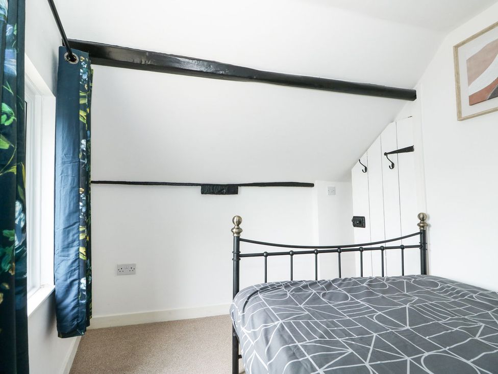 A bedroom with a bed and curtains at Oar Cottage in Mablethorpe