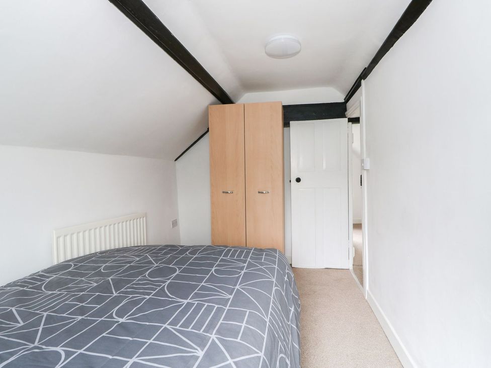 A bedroom with a bed and wardrobe at Oar Cottage Mablethorpe
