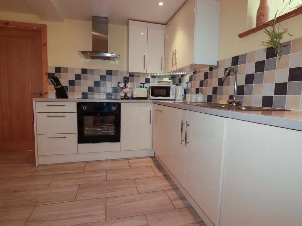 A kitchen with cabinets, oven, sink, and appliances at The Water Mill at Boyton Mill, Launceston