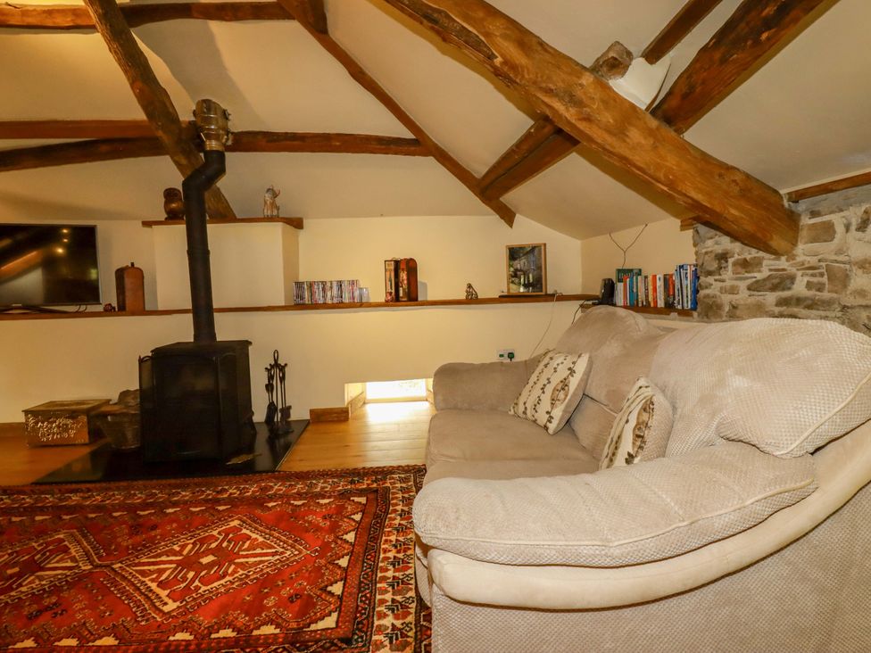 A living room with a sofa and a wood stove at The Water Mill at Boyton Mill Launceston