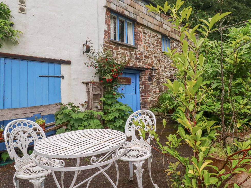 A garden with a table and chairs at The Water Mill at Boyton Mill Launceston