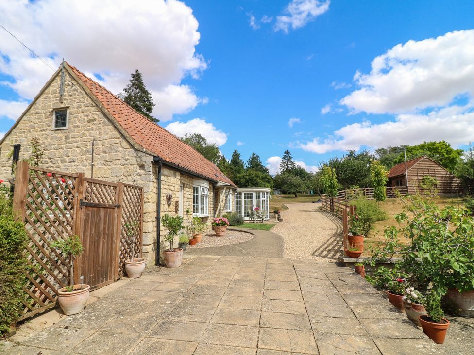 An outdoor area with a house and pathway at Wheelwrights Cottage in Corby Glen
