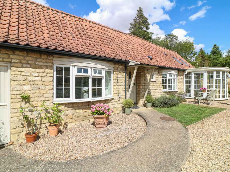 An outdoor view of a house with garden features at Wheelwrights Cottage in Corby Glen