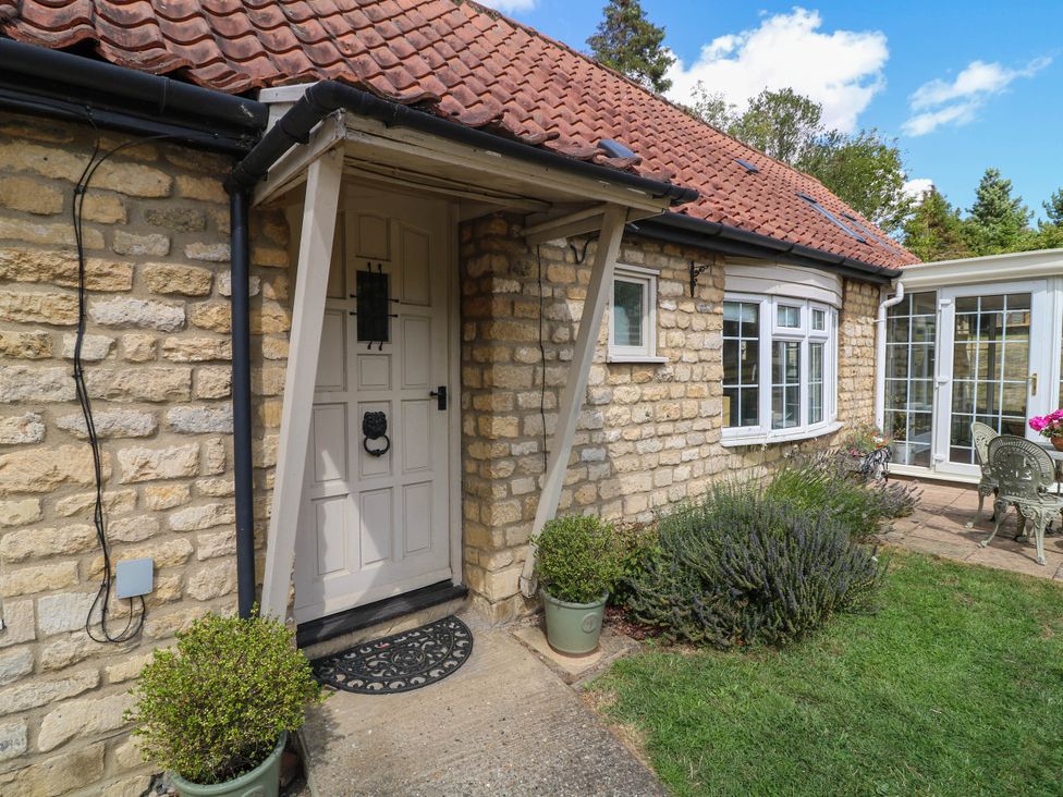An entrance with a door and plants at Wheelwrights Cottage in Corby Glen