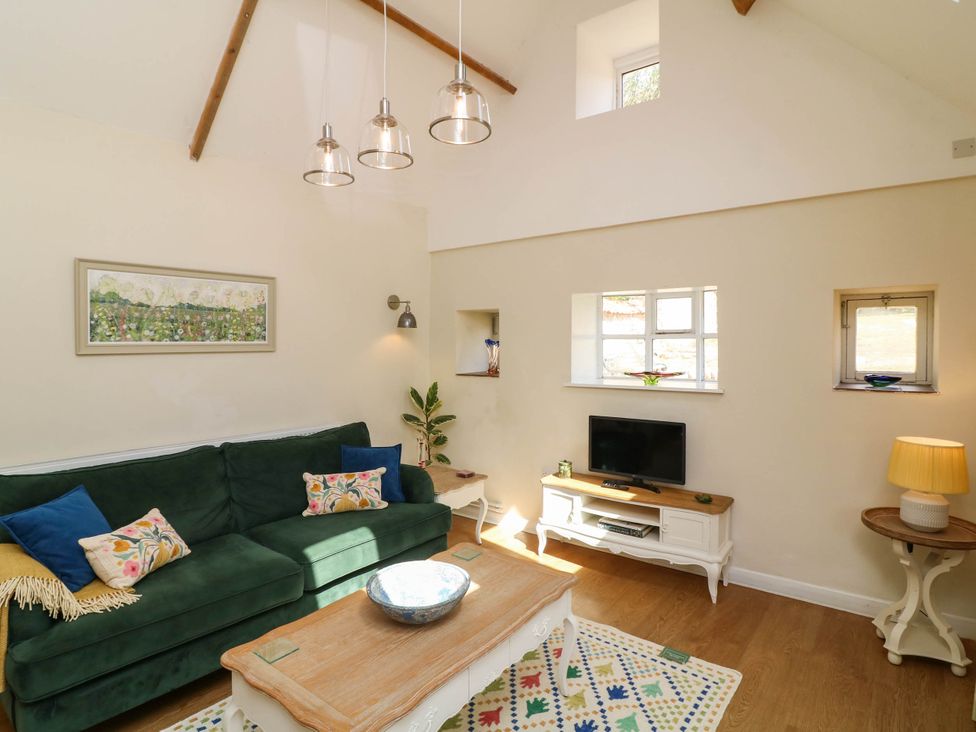 A living room with a sofa and television at Wheelwrights Cottage in Corby Glen