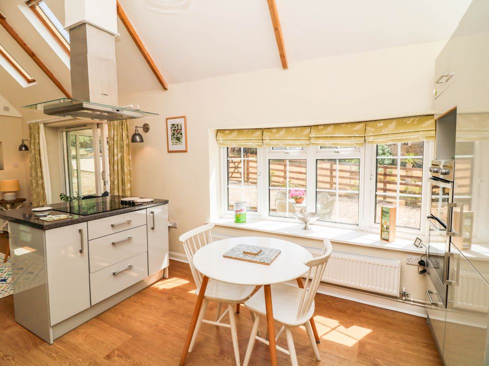 A kitchen with a table and chairs at Wheelwrights Cottage in Corby Glen