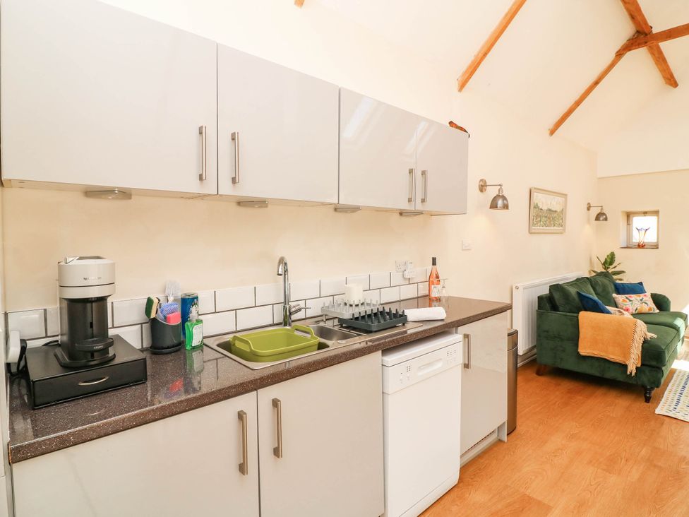 A kitchen with countertop appliances and a sofa at Wheelwrights Cottage in Corby Glen