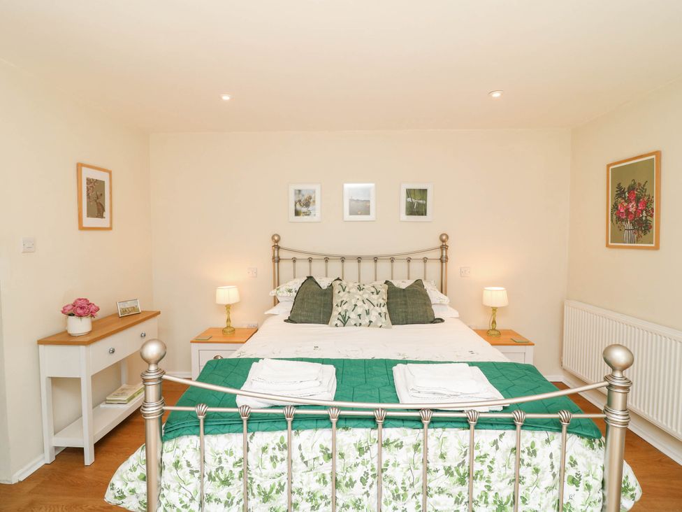 A bedroom with a bed and nightstand at Wheelwrights Cottage in Corby Glen