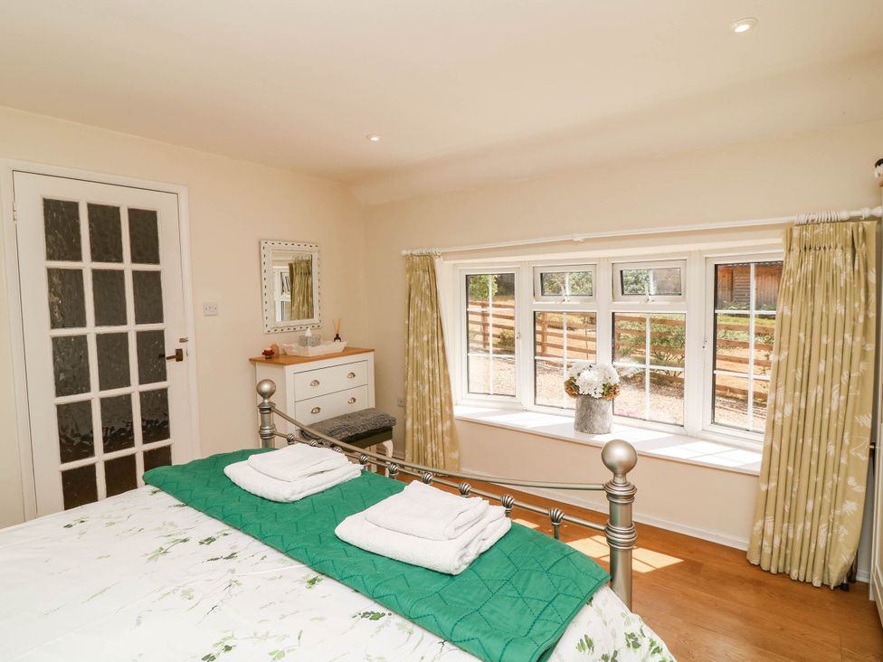 A bedroom with a bed and window at Wheelwrights Cottage in Corby Glen