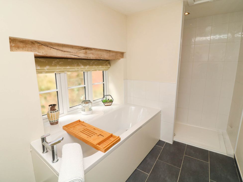 A bathroom with a bathtub and shower at Wheelwrights Cottage in Corby Glen