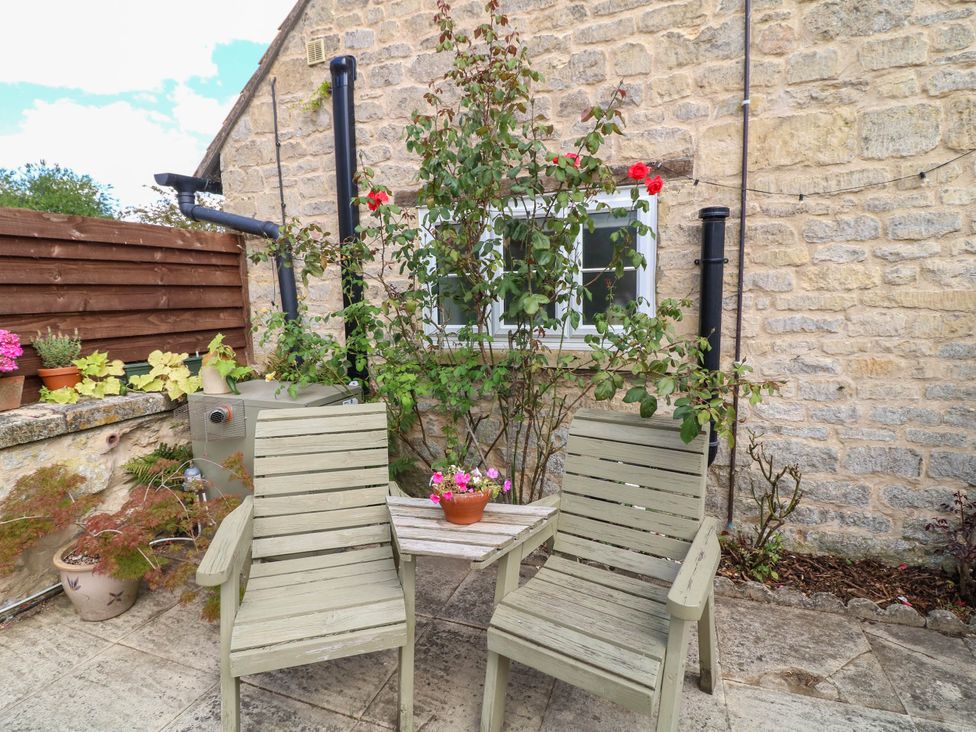A garden seating area with two chairs and a table at Wheelwrights Cottage in Corby Glen