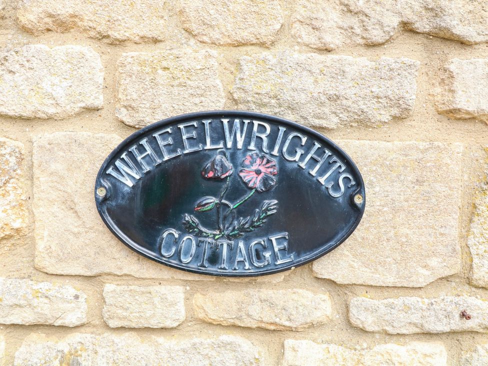A nameplate on a stone wall at Wheelwrights Cottage in Corby Glen