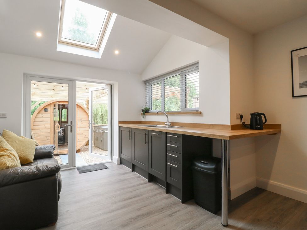 A kitchen with a sink and door leading outside at The Kingfisher Falls in Melton Mowbray