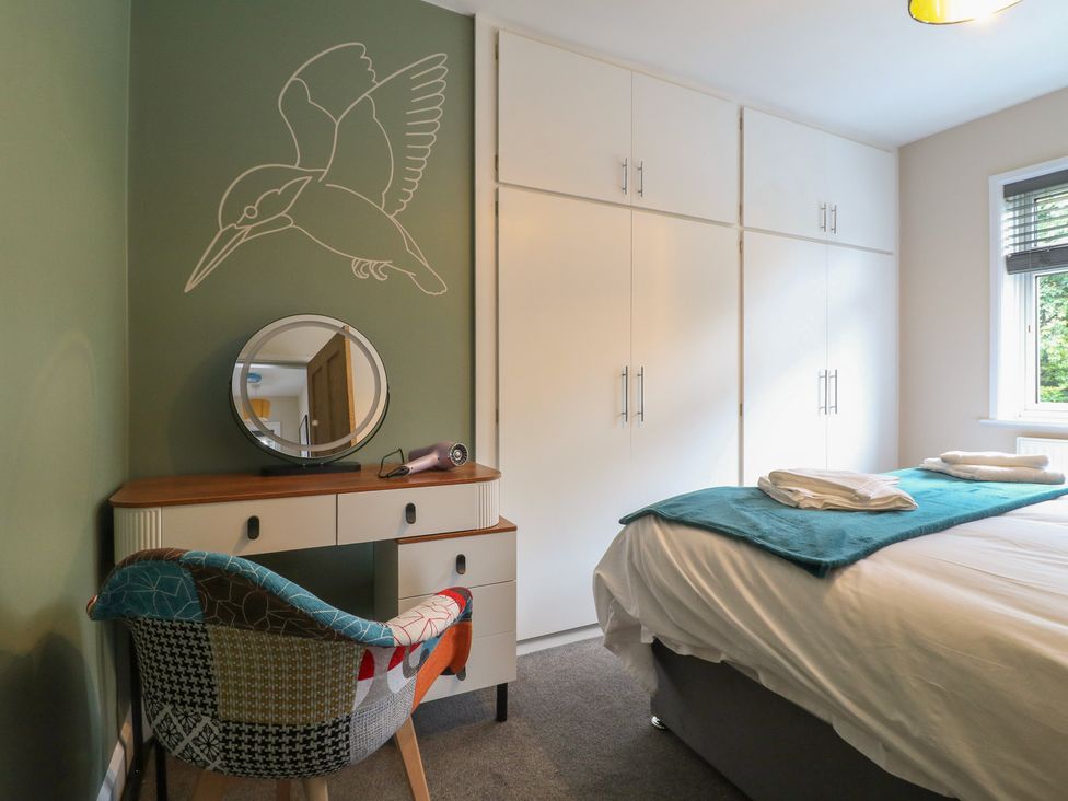 A bedroom with a bed and a mirror at The Kingfisher Falls in Melton Mowbray