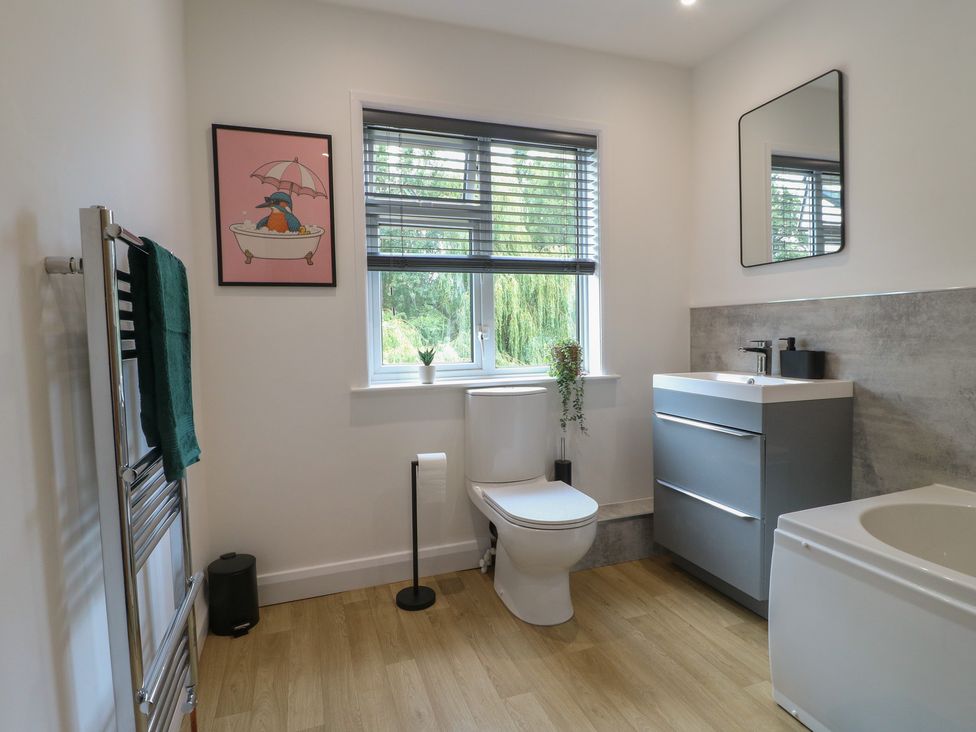 A bathroom with a toilet, sink and bathtub at The Kingfisher Falls in Melton Mowbray