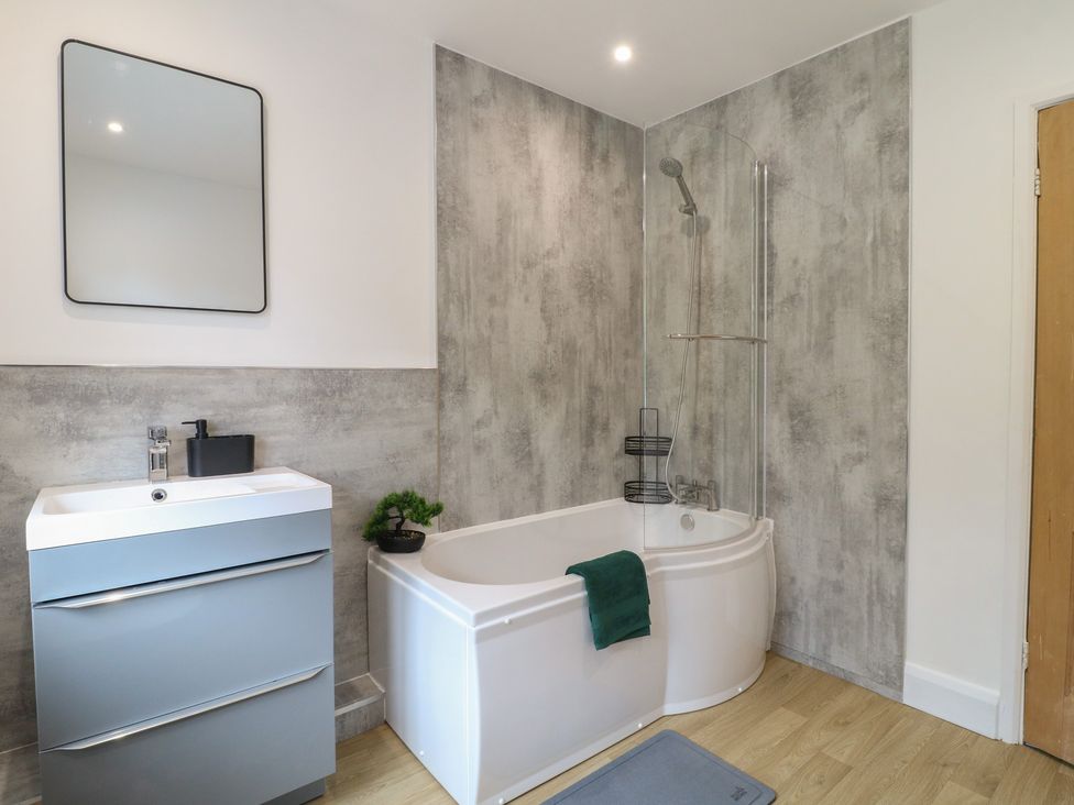 A bathroom with a bathtub and sink at The Kingfisher Falls in Melton Mowbray