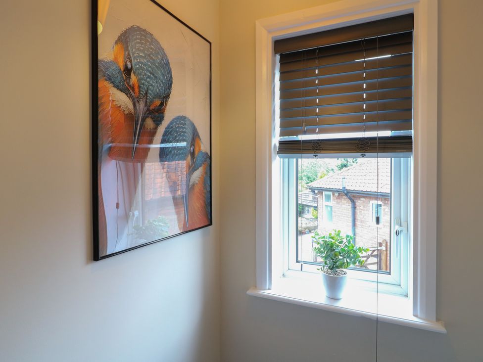 A wall with artwork and a window with blinds at The Kingfisher Falls in Melton Mowbray