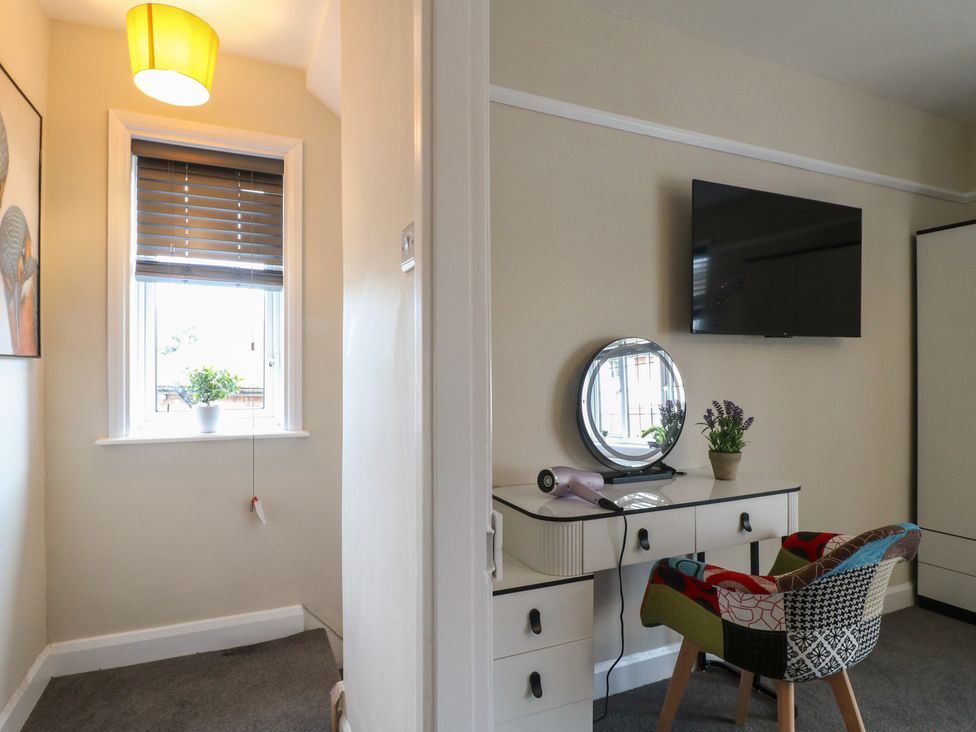 A bedroom with a desk and mirror at The Kingfisher Falls in Melton Mowbray