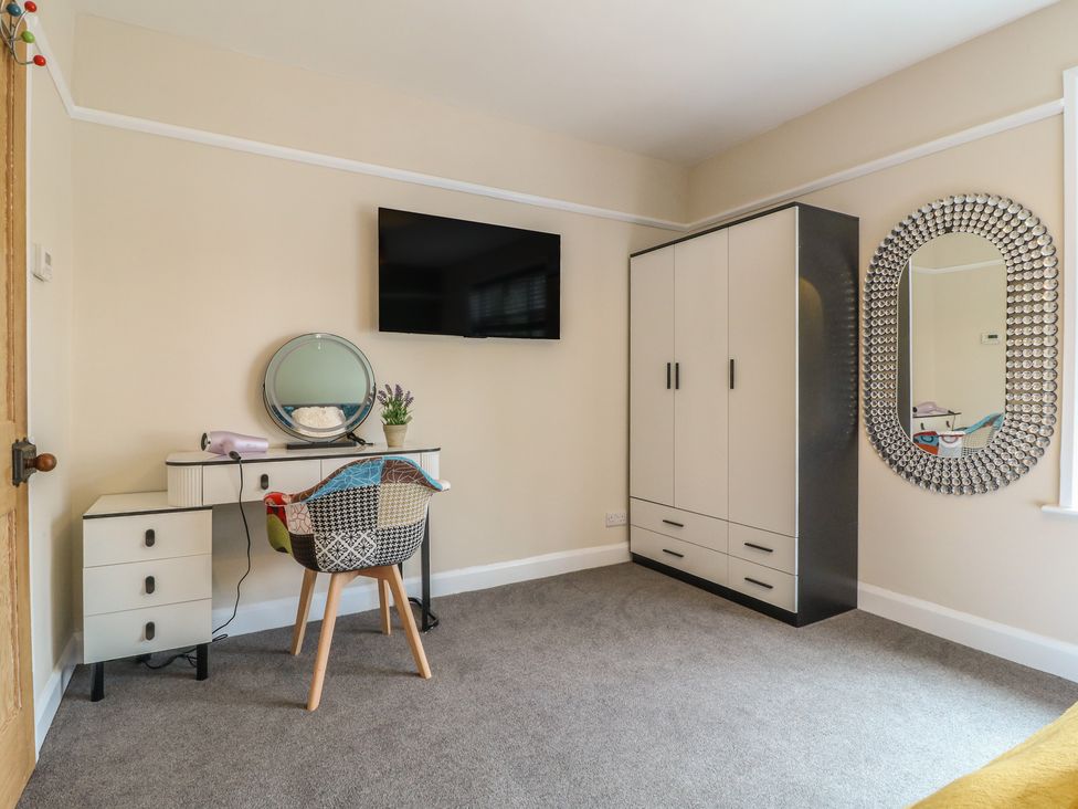 A bedroom with a wardrobe and a desk at The Kingfisher Falls in Melton Mowbray
