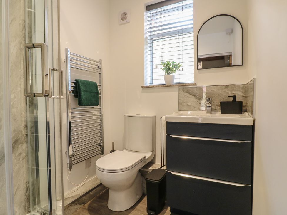 A bathroom with a sink, toilet, and shower at The Kingfisher Falls in Melton Mowbray