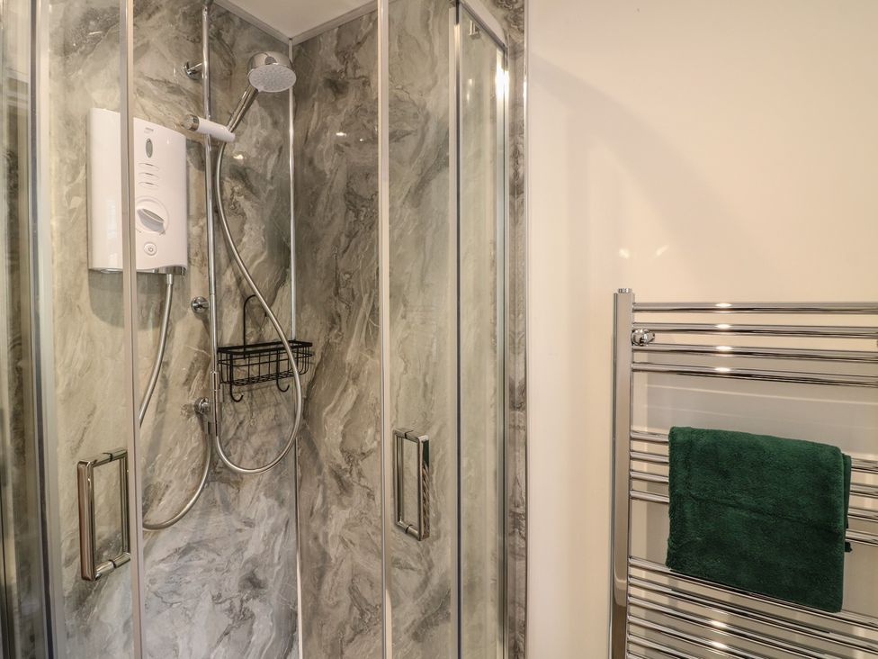 A shower with glass enclosure and towel rail at The Kingfisher Falls in Melton Mowbray