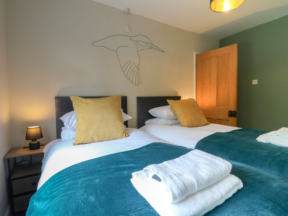 A bedroom with two beds and a lamp at The Kingfisher Falls in Melton Mowbray
