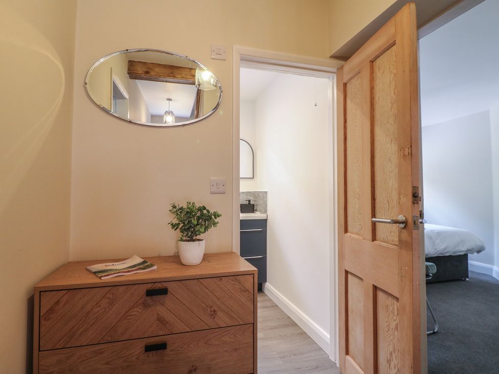 A hallway with a drawer unit and a mirror at The Kingfisher Falls in Melton Mowbray