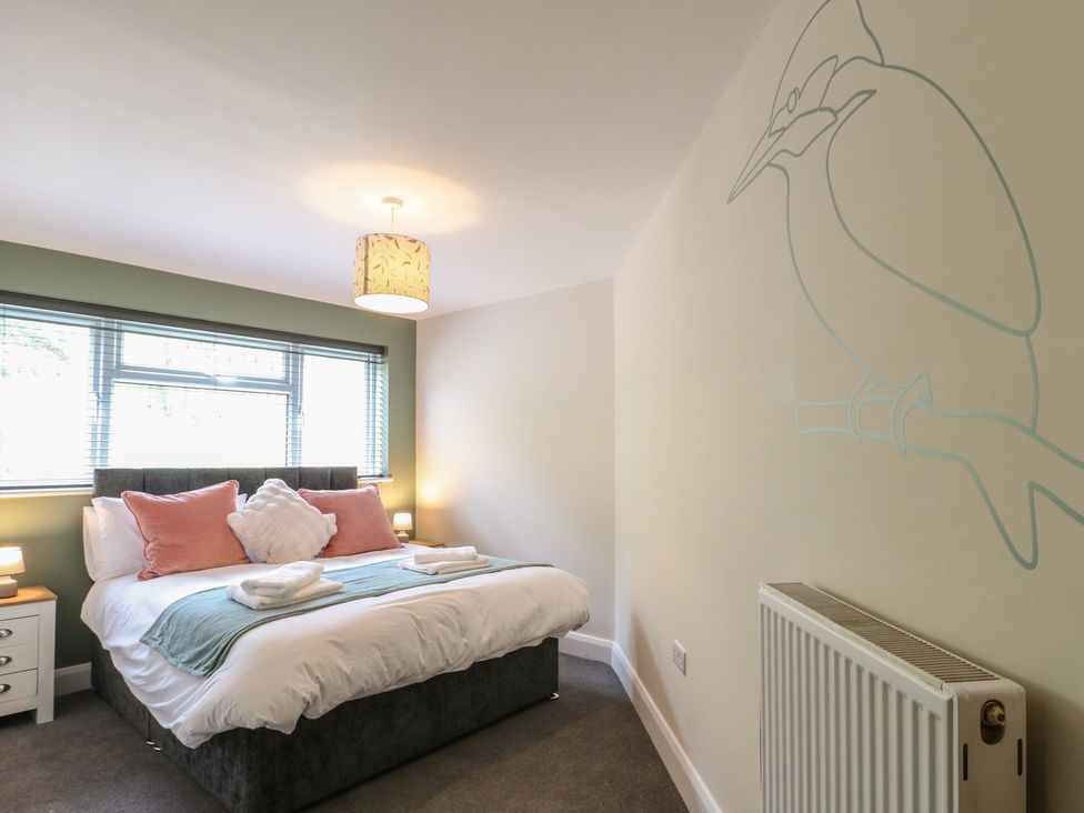 A bedroom with a bed and bedside table at The Kingfisher Falls in Melton Mowbray