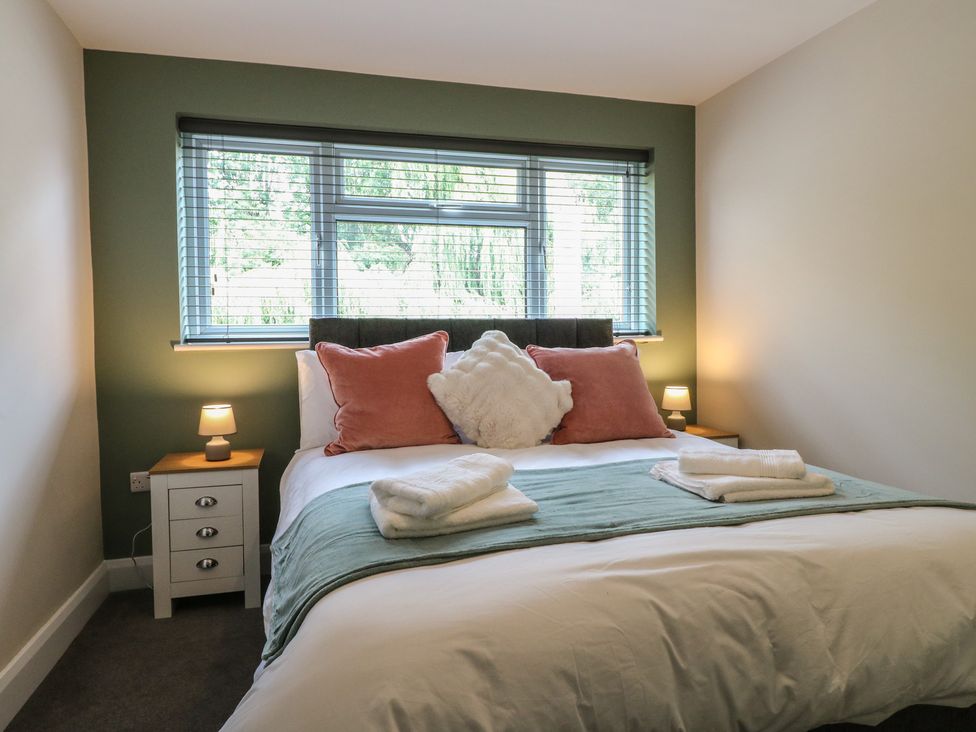 A bedroom with a bed and nightstand at The Kingfisher Falls in Melton Mowbray