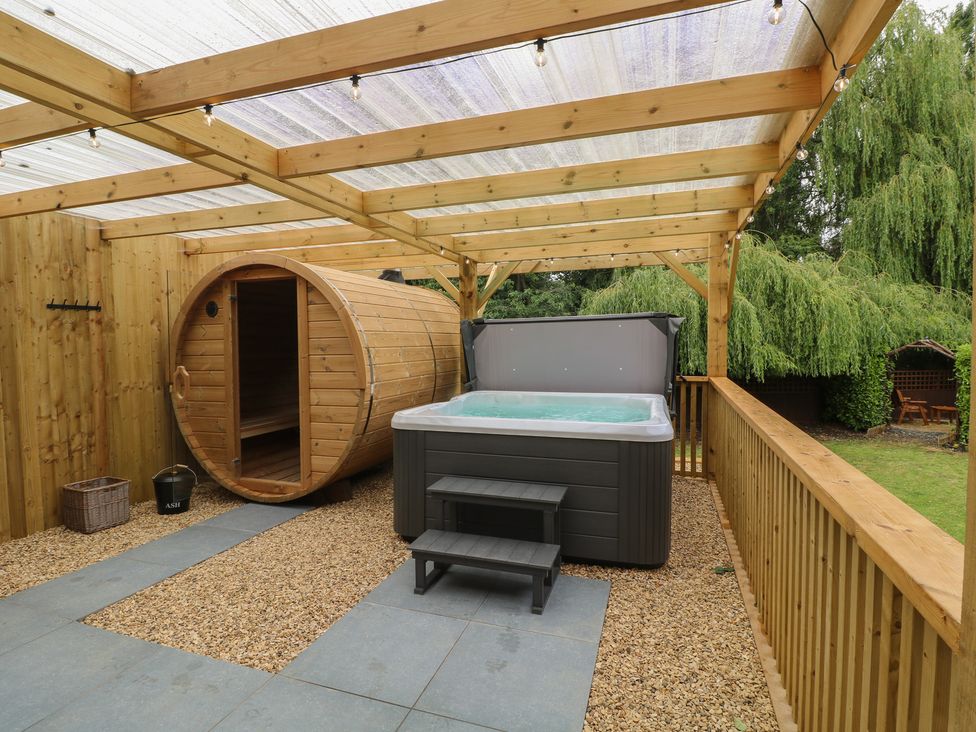 A garden with a hot tub and sauna at The Kingfisher Falls in Melton Mowbray