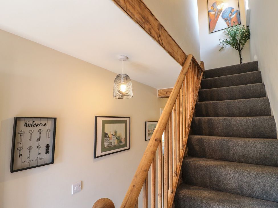 A stairway with artwork and a decorative plant at The Kingfisher Falls in Melton Mowbray