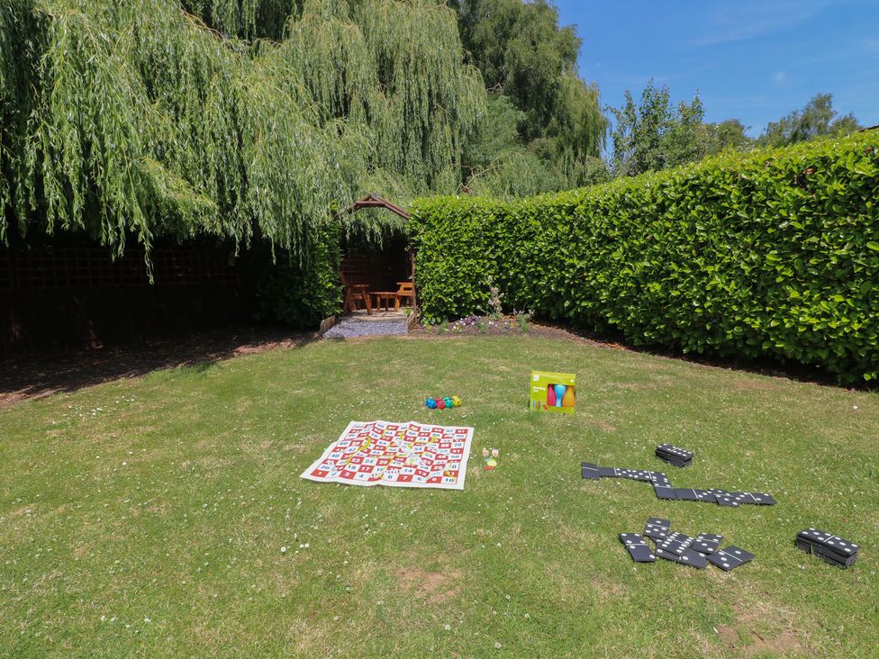 A garden with a blanket and games at The Kingfisher Falls in Melton Mowbray
