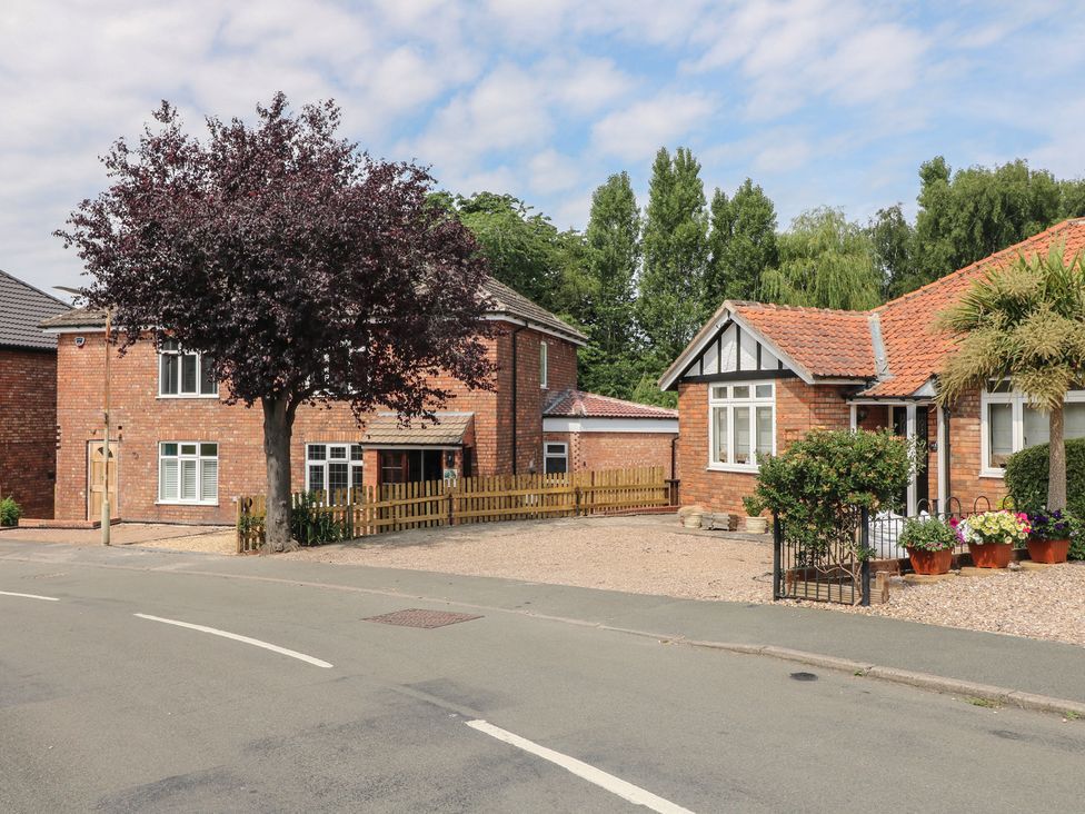 Two brick houses with a fence and trees at The Kingfisher Falls in Melton Mowbray