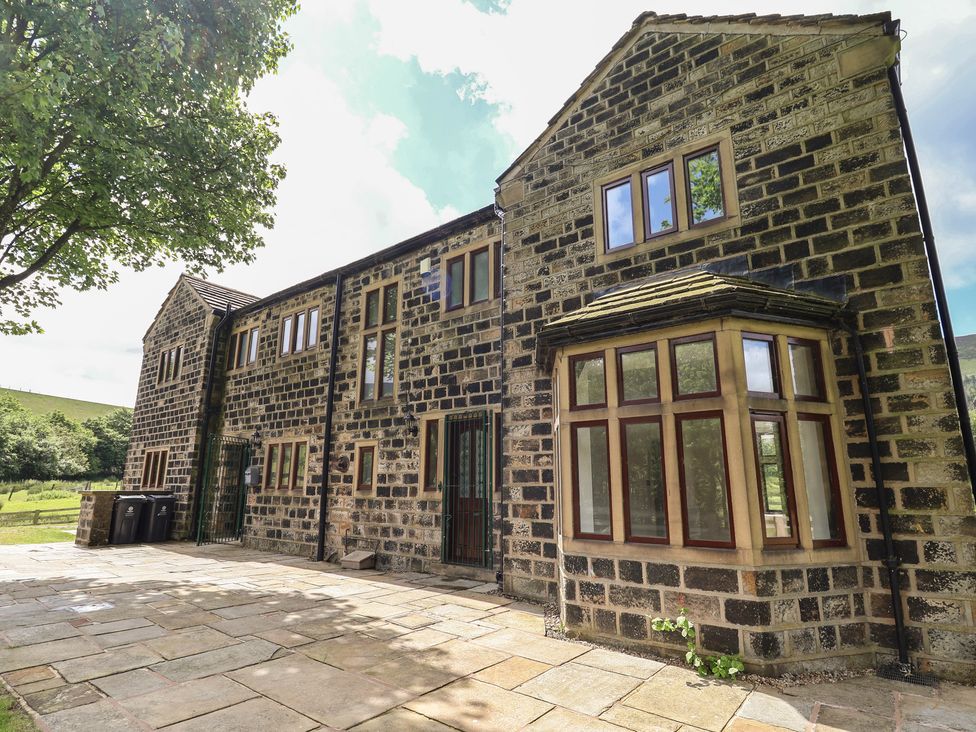An outdoor view of a stone building with windows and patio at Greenfield Manor near Greenfield