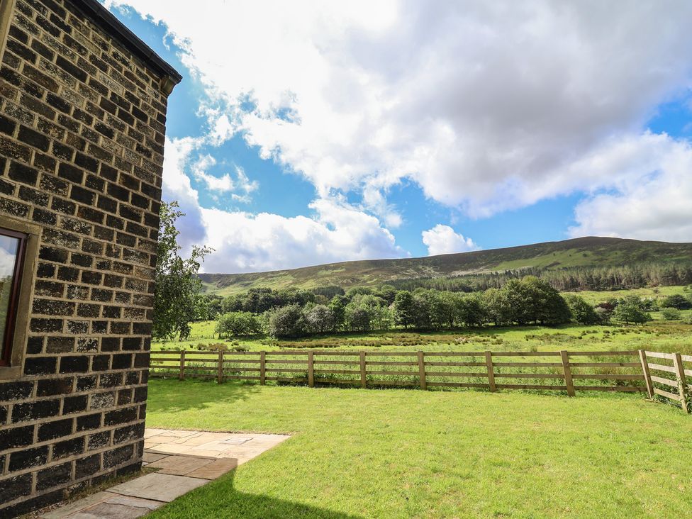 An outdoor area with a stone wall and grassy space at Greenfield Manor near Greenfield