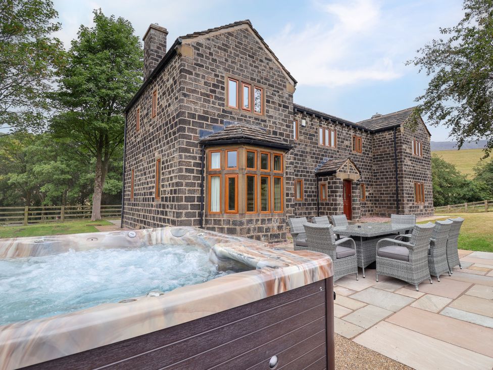 An outdoor area with a hot tub and dining furniture at Greenfield Manor near Greenfield