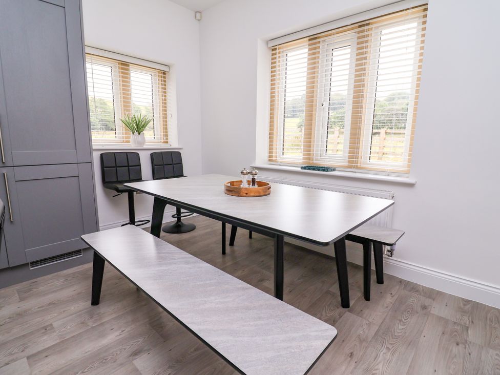 A dining room with a table and benches at Greenfield Manor near Greenfield