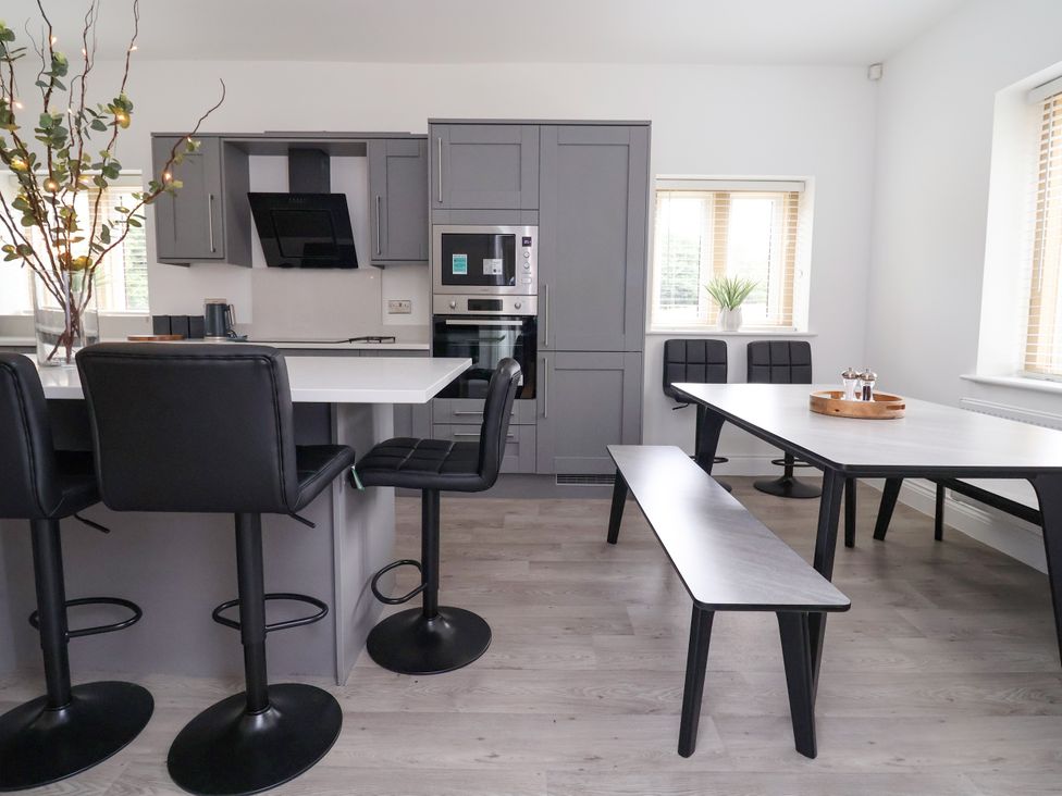 A kitchen with bar stools and dining table at Greenfield Manor near Greenfield
