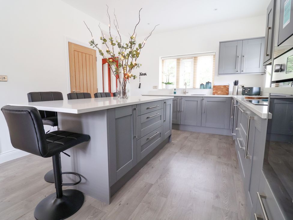 A modern kitchen with a kitchen island and bar stools at Greenfield Manor near Greenfield